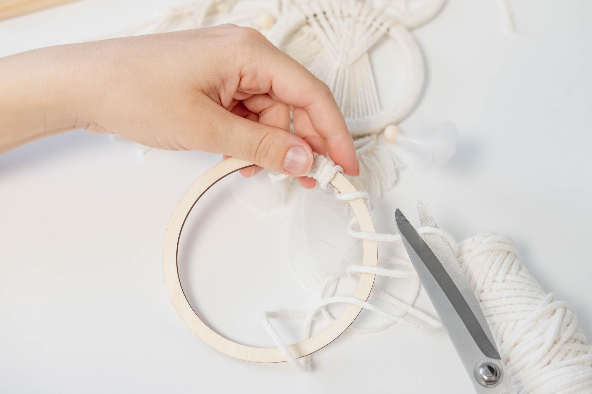 Woman stitching colorful floral embroidery on hoop